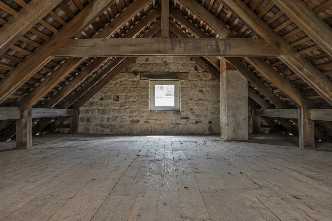 Illustration générée de combles avant isolation du plancher.